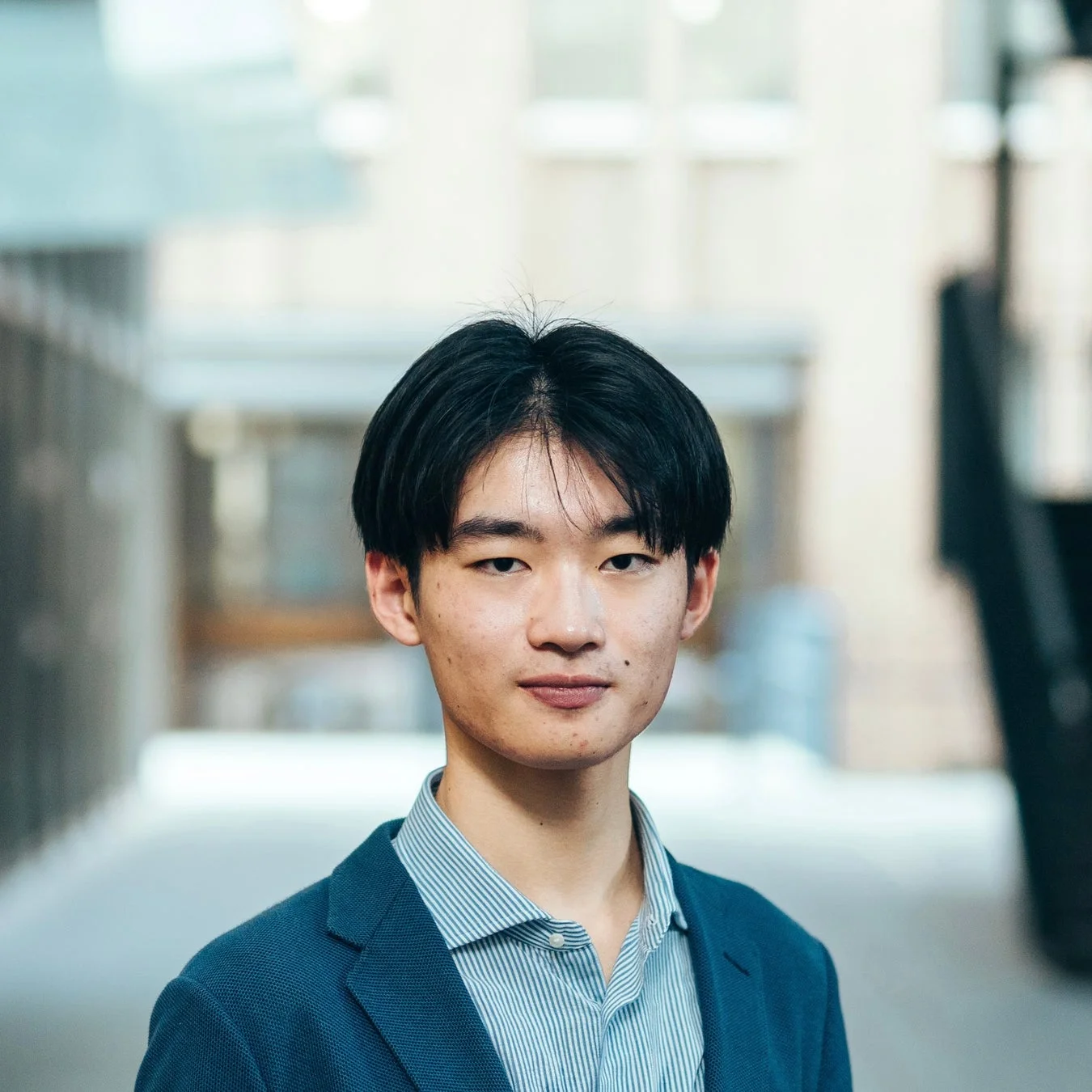 青いジャケットとストライプのシャツを着た若いアジア人男性のポートレート