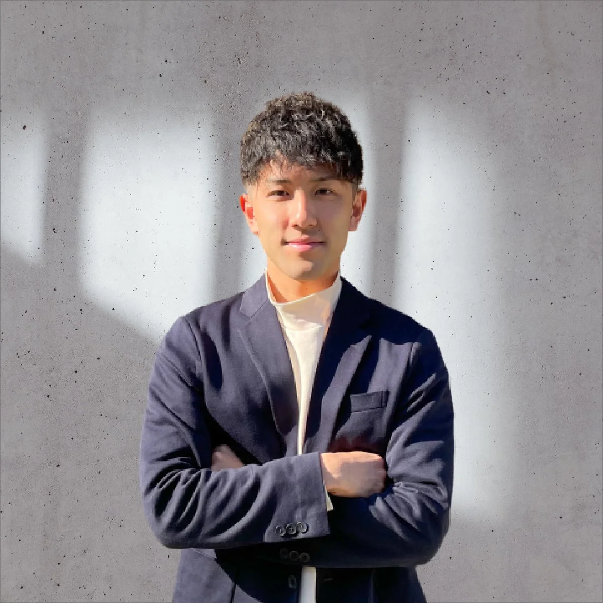 紺色のジャケットと白いタートルネックを着用した若い男性